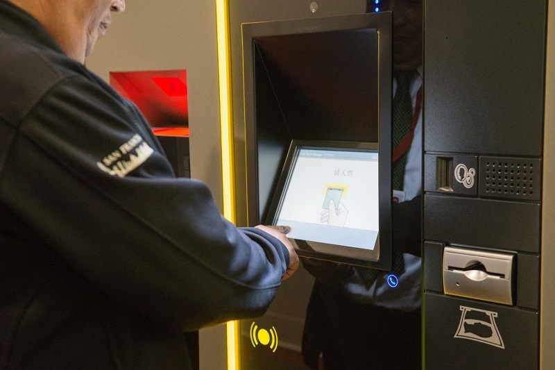 A man uses a touch screen for the new parking garage payment system.