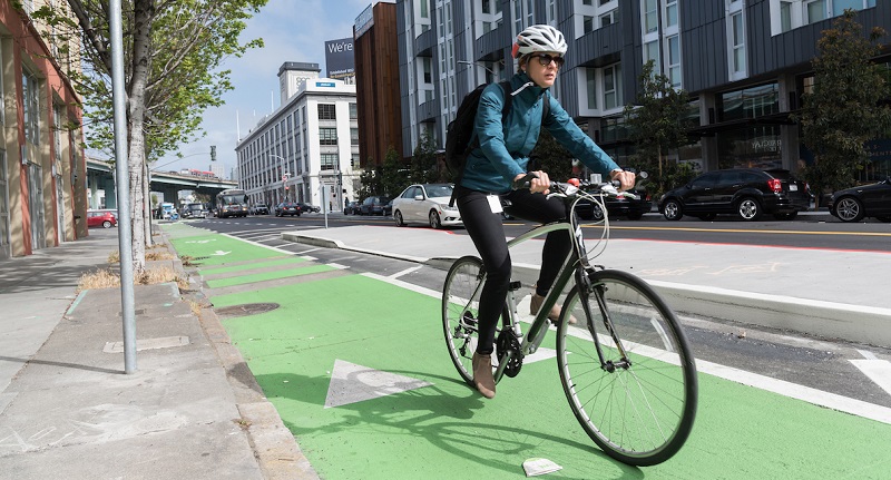 Person biking on our new protected bikeway on 8th Street.