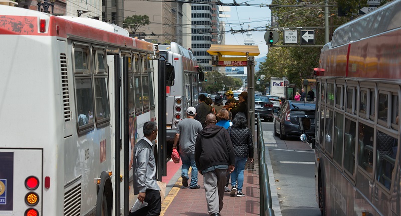 People boarding buses downtown.