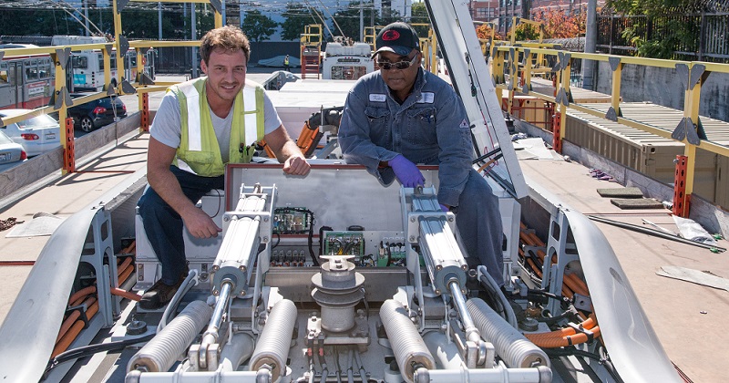 Men working on top of a bus.