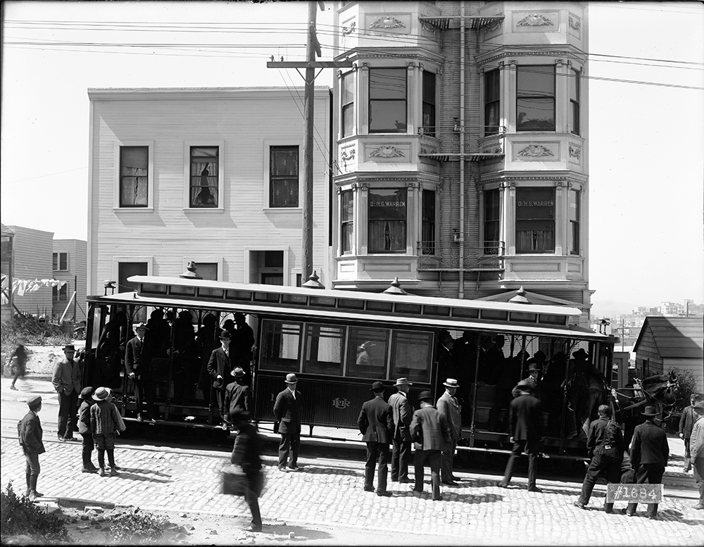 cable car full of people with people in street around it