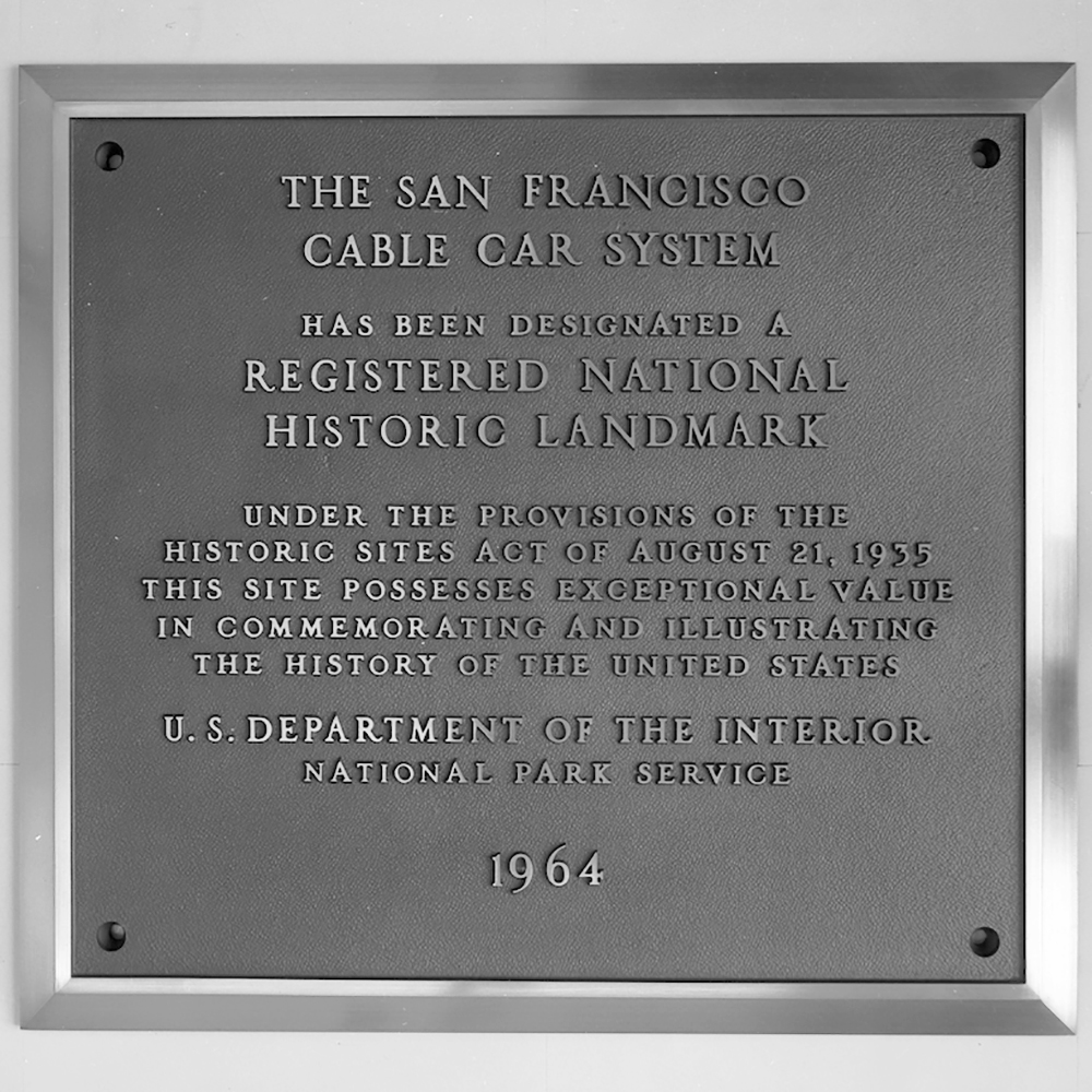 plaque for cable car national landmark status. Plaque reads: The San Francisco Cable Car System has been designated a Registered National Historic Landmark Under the provisions of the historic sites act of August 21, 1935, this site possesses exceptional value in commemorating and illustrating the history of the United States. U.S. Department of the Interior, National Park Service, 1964