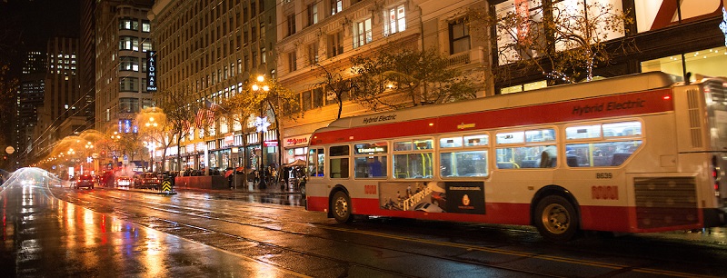 Coach traveling down a rainy street.