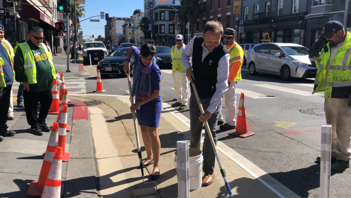 Tom Maguire and Viktoriya Wise painting sidewalk zones.