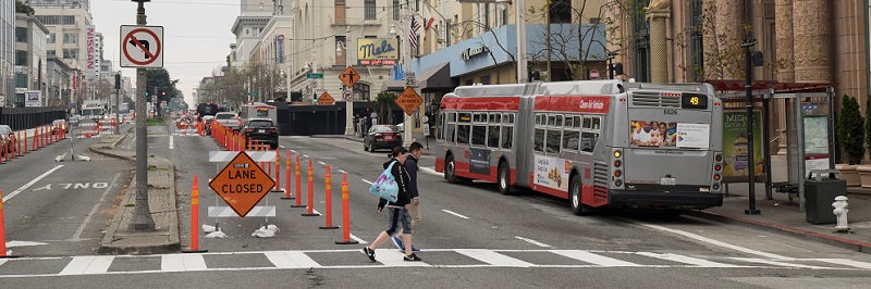People crossing Van Ness at a crosswalk