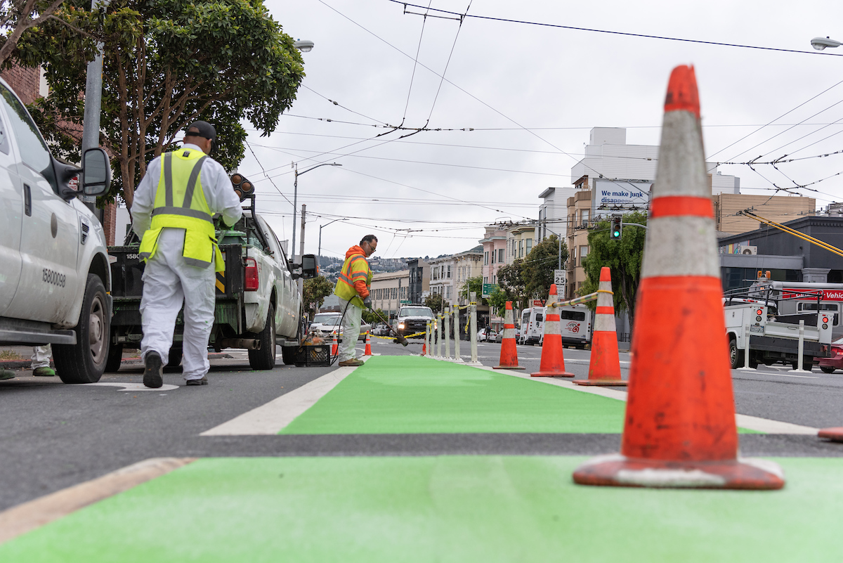 crews installing green bike paths