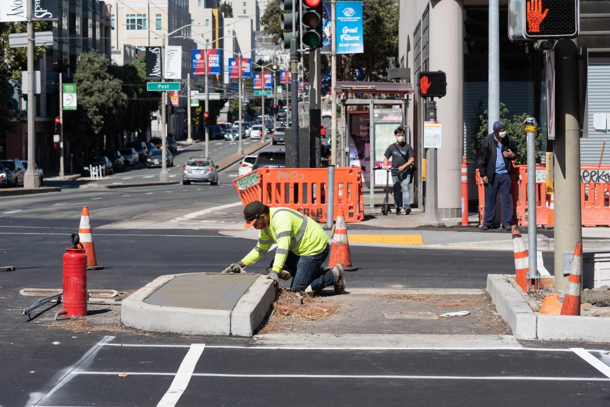Crews finishing concrete on the expanded center median pedestrian refuge at Divisadero and Geary streets.