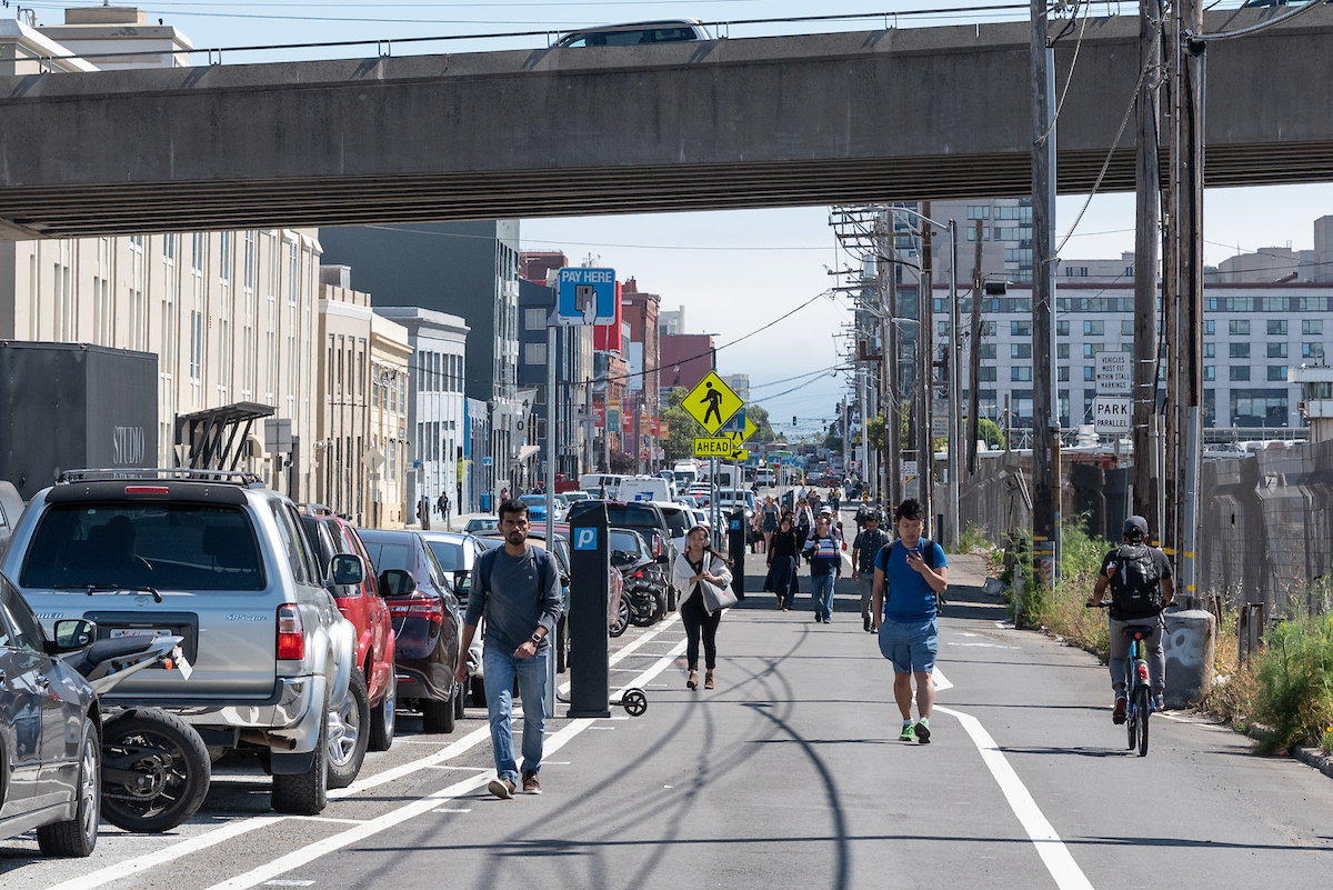 People walking under the freeway in the afternoon