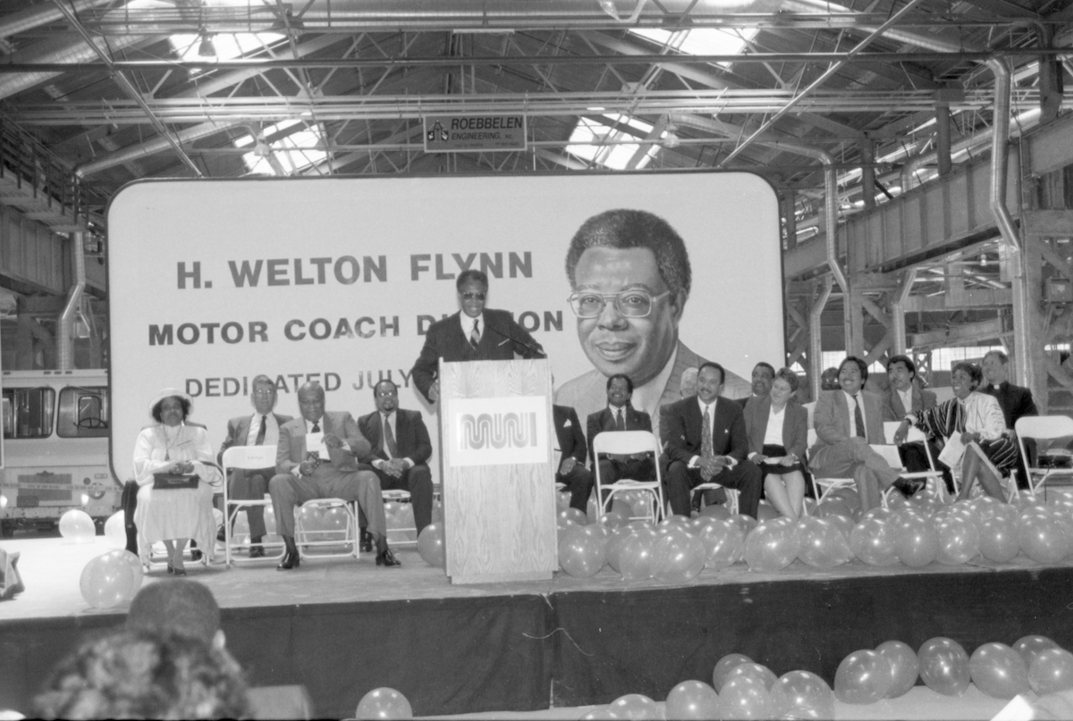 group of people seated in front of stage with person standing on it