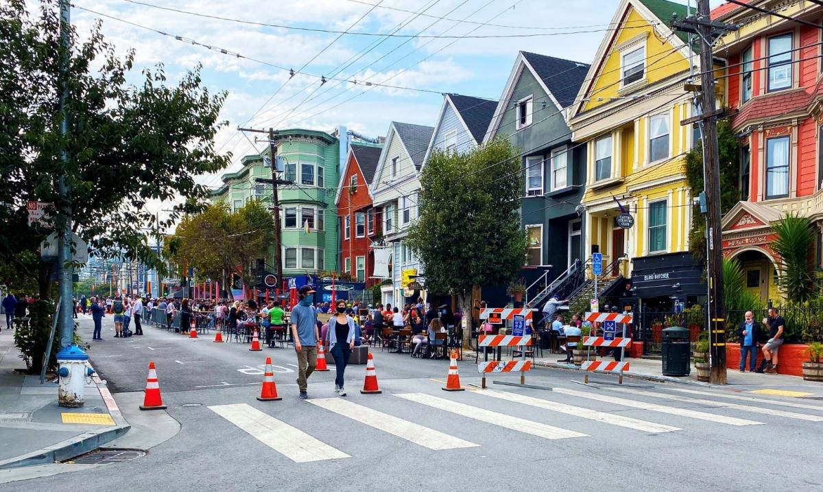 The 18th Street Shared Space with people eating and walking with traffic cones to prevent cars.