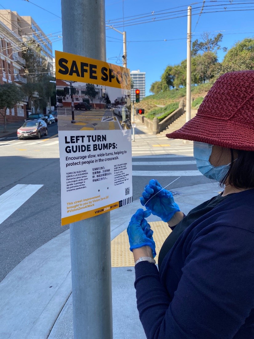 An outreach worker puts up a poster.