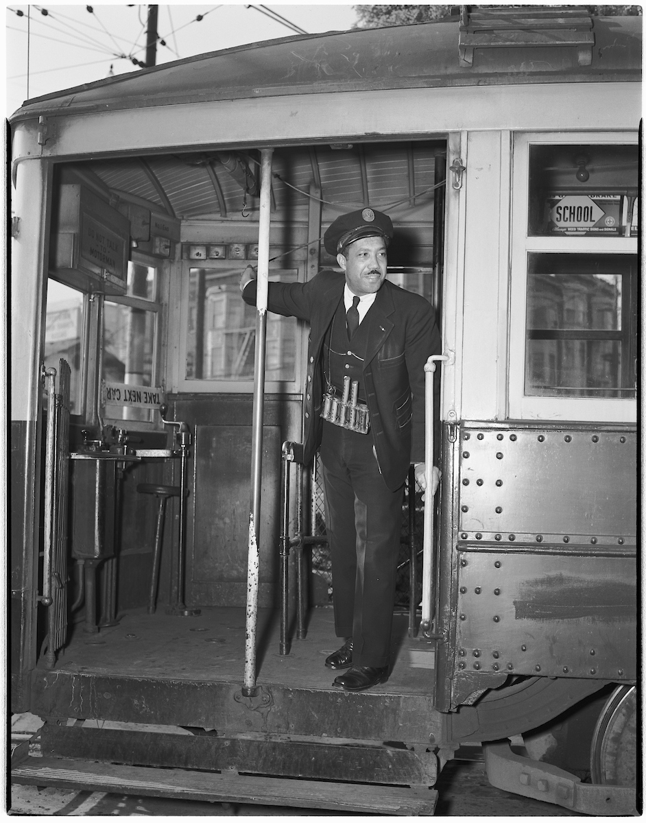 conductor standing at door of streetcar looking out