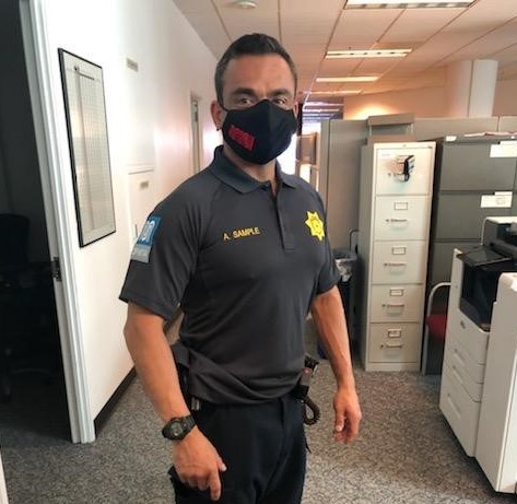 A Transit Fare Inspector wears a new uniform and Muni face covering.