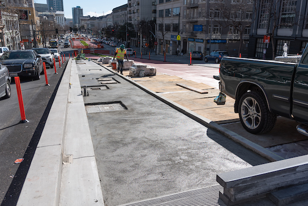 Looking south at crew member laying concrete between Eddy and Larch on Van Ness. 