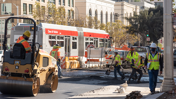 Crew members laying concrete on the southwest corner at Van Ness and Sutter 
