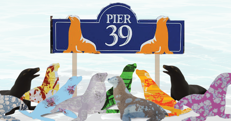 Multicolored seals covered in various patterns in front of a Pier 39 sign which features two seals, with pale water in the background.