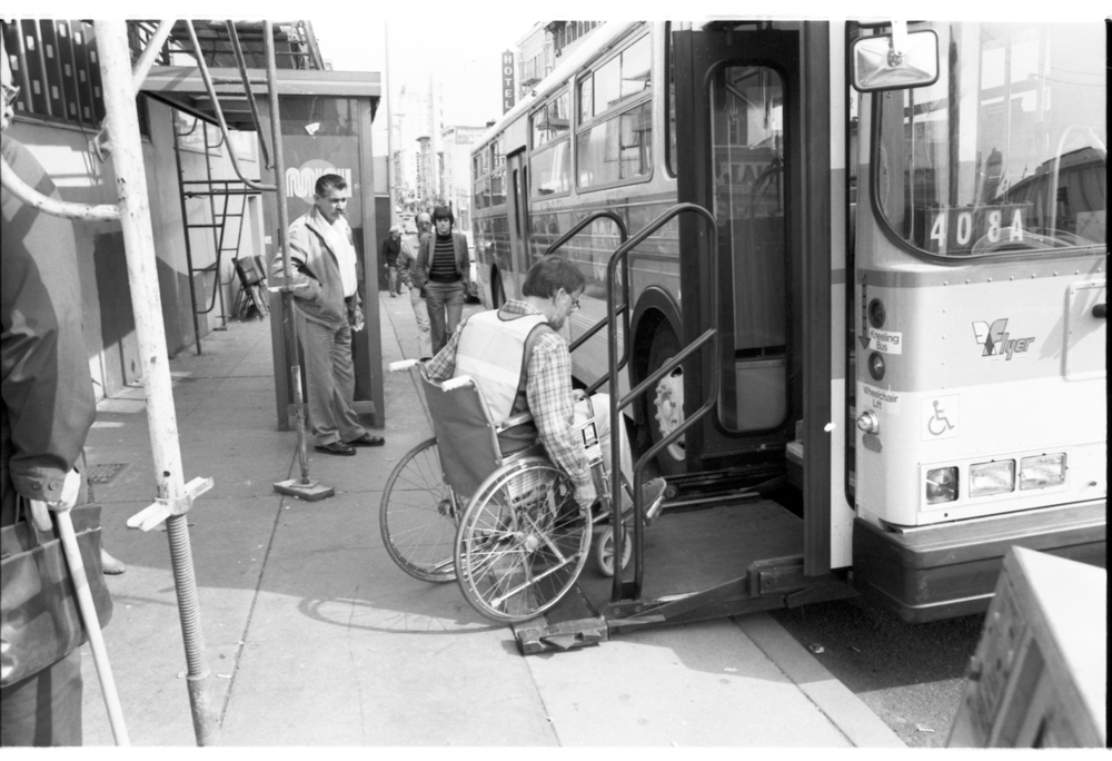 person sitting in wheelchair boarding bus