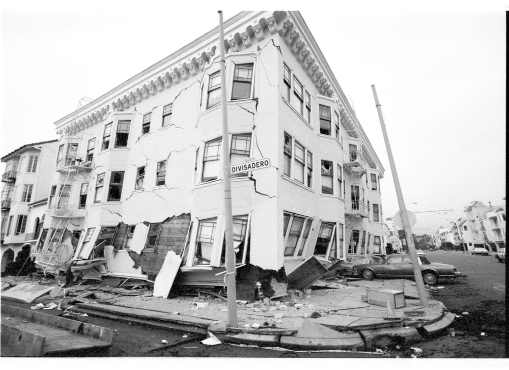 building slumped over, with cracked and damaged walls after earthquake