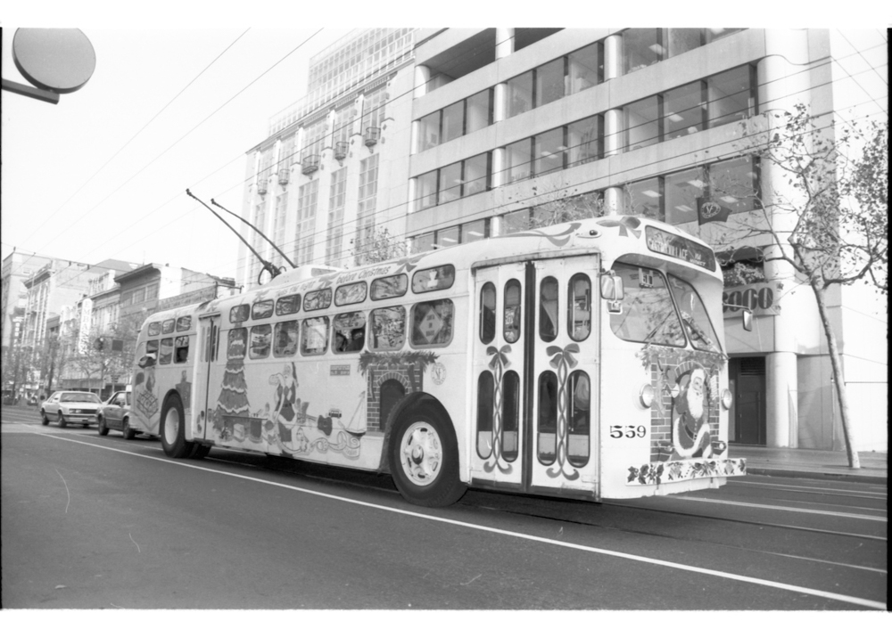 trolley bus painted with christmas decorations including fireplaces, santa claus figures and candy canes