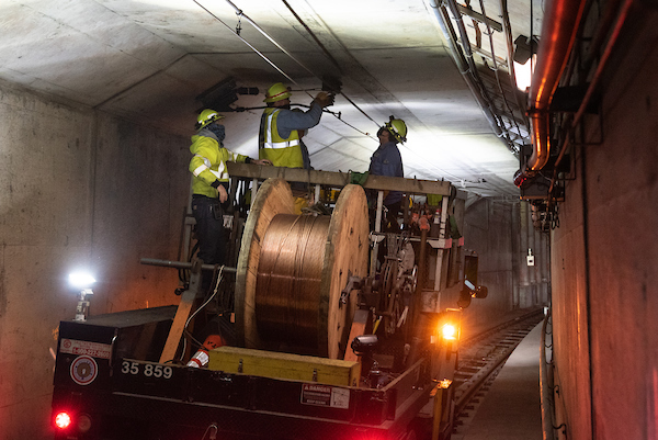 Photo of crew installing overhead wire in the subway tunnel