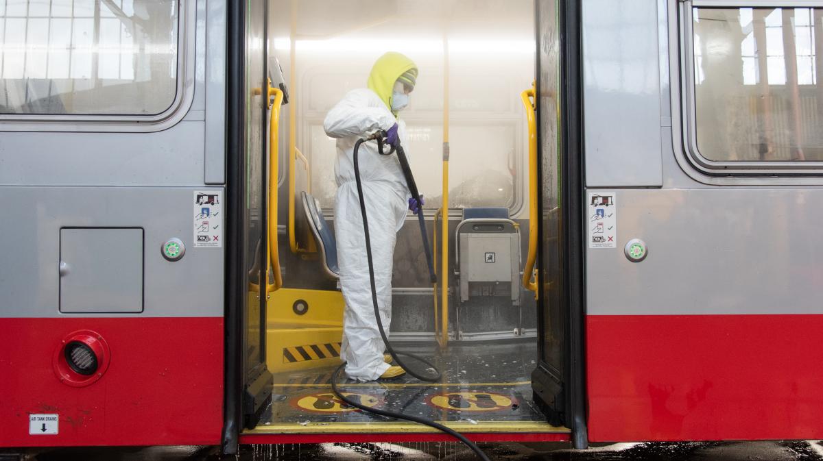 Photo of a car cleaner sanitizing a Muni bus