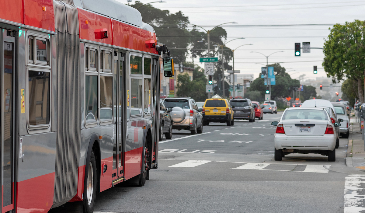 photo of Temporary curbside transit lanes striped with white paint and “Bus/Taxi Only” stenciling and signage. 