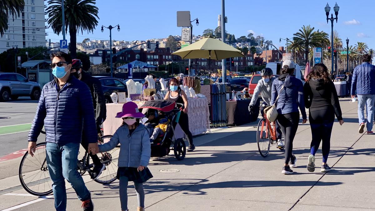 Image of people walking and bicycling on the Embarcadero's shared-use promenade just north of the Ferry Building