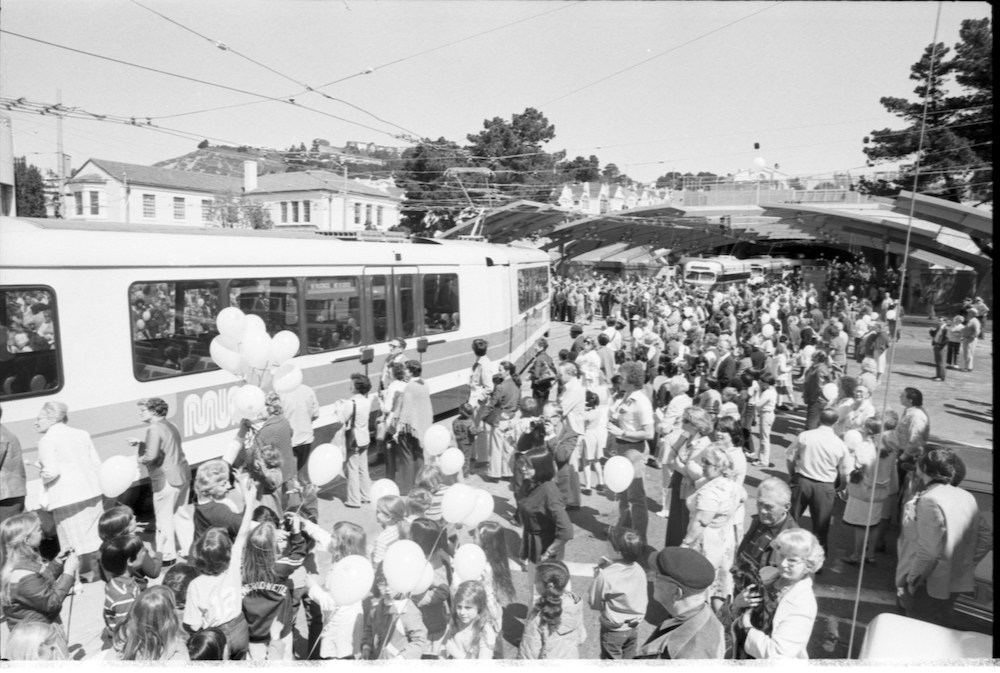 crowd of people and streetcars outside West Portal station