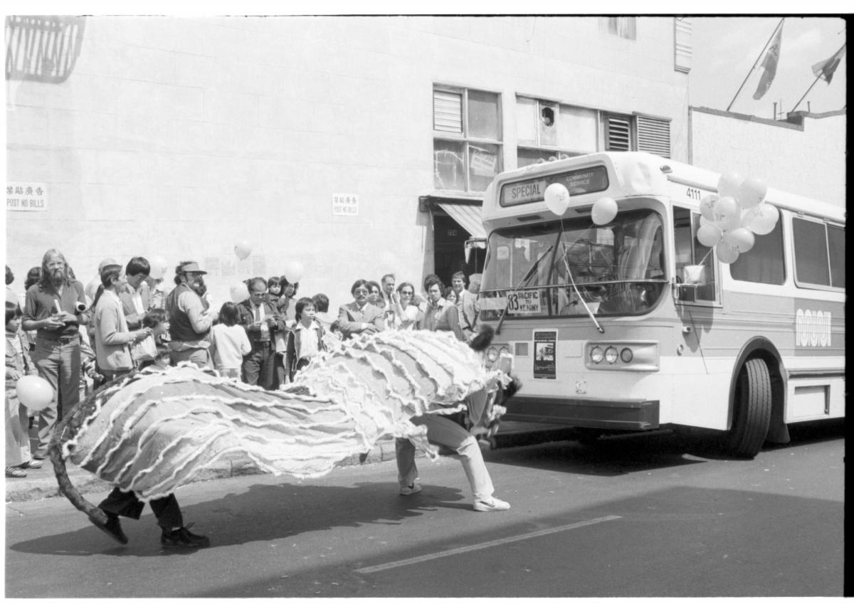 Lion dancers performing in front of a Muni bus