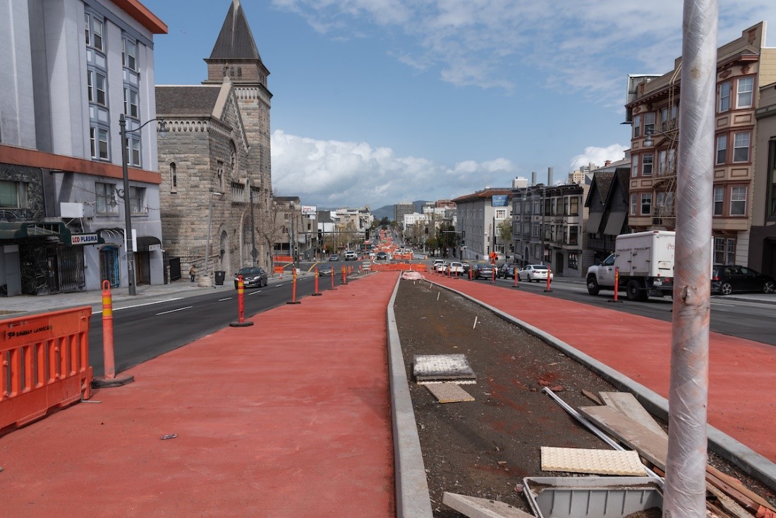 Photo of red colored concrete freshly poured on Van Ness Avenue, to create new bus rapid transit lanes 