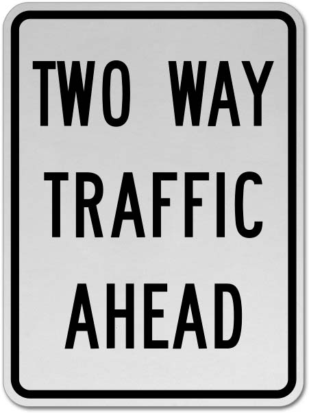 Road sign reading "two way traffic ahead"