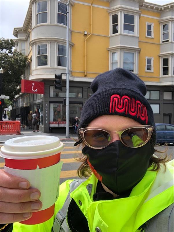 Photo depicting a Muni staff person holding a cup of coffee.