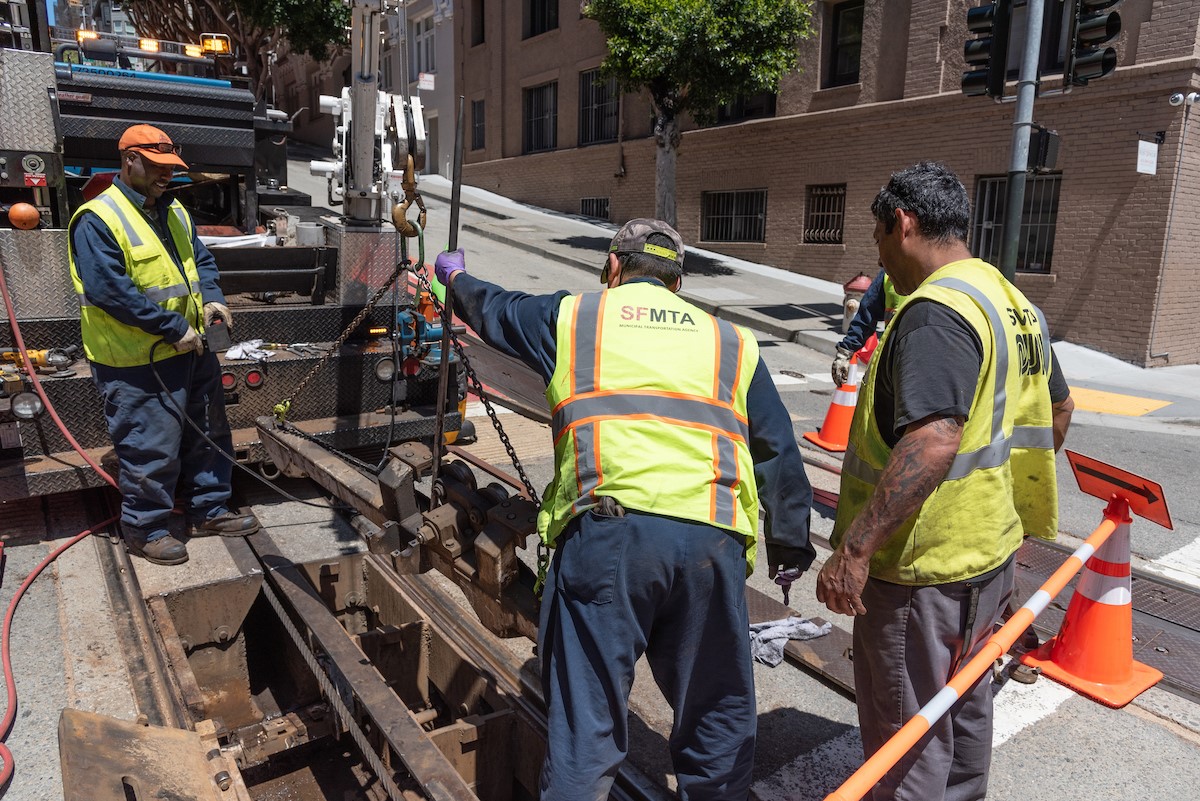 A track crew replaces an old depression beam