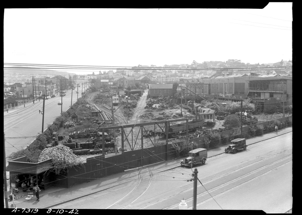 A view inside the overhaul shop in 1912 showing a row of streetcars at left and staff tearing down trucks and motors at right.