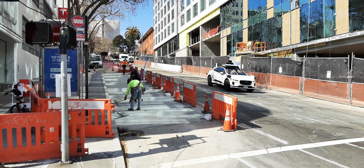 Crew members spreading concrete for the new bus pad at O’Farrell and Van Ness.  