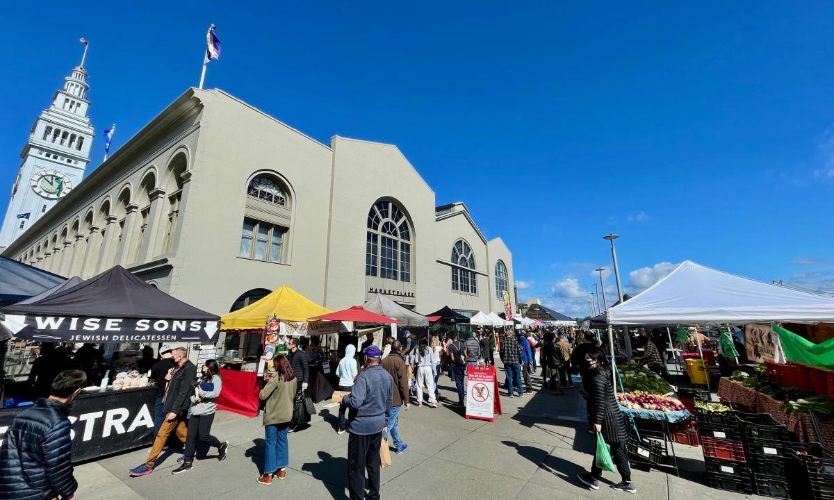 Image of the farmers market on the south side of the Ferry Building on a sunny Saturday with blue skies aloft.