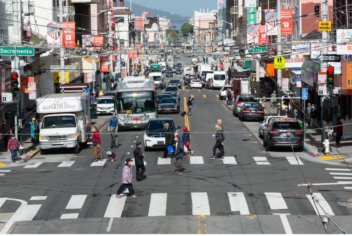 A pedestrian scramble at Sacramento Street: the traffic signals are arranged so cars stop in all directions, and pedestrians are crossing in any direction through the intersection.