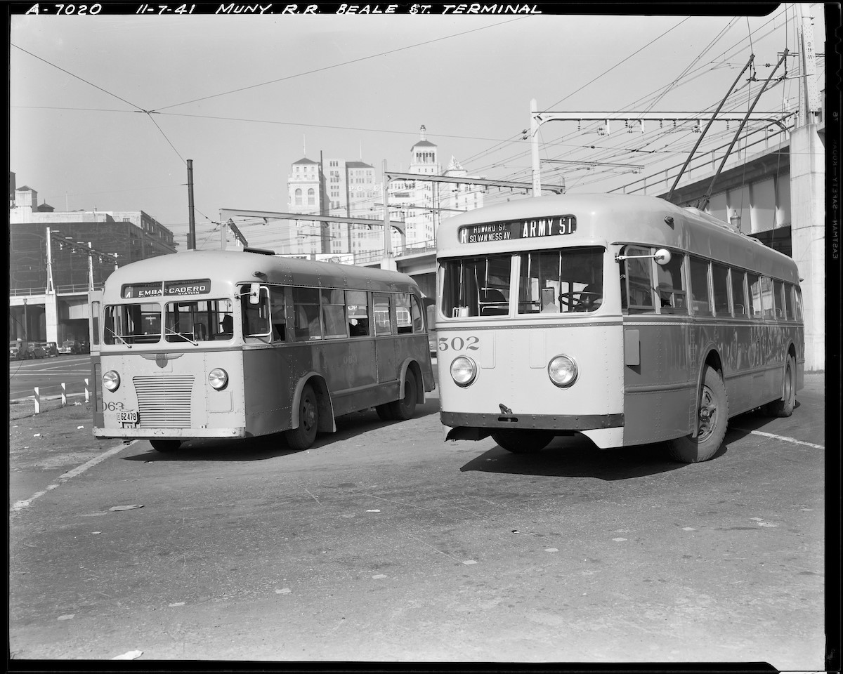 Two Muni buses lay over at the “Bridge Terminal” at Beale and Howard Streets in this November 1941 photograph. At left is the 4 Embarcadero, which ran along the waterfront and the recently established R Howard trolley bus at right.