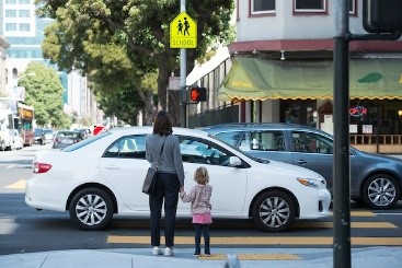 A mother and daughter crossing the street.