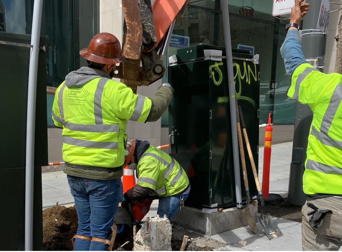 Crew members working to replace light poles at southwest corner of Van Ness and Sutter