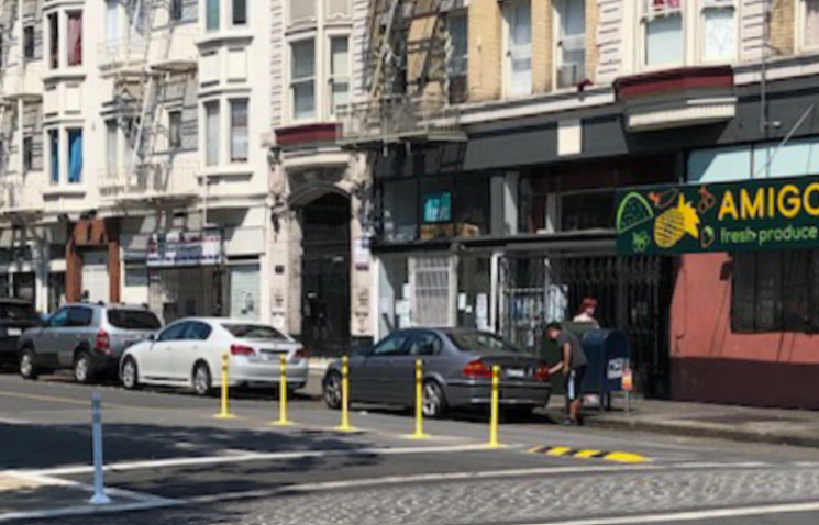 photo of plastic safety posts separating a bike lane from a general traffic lane