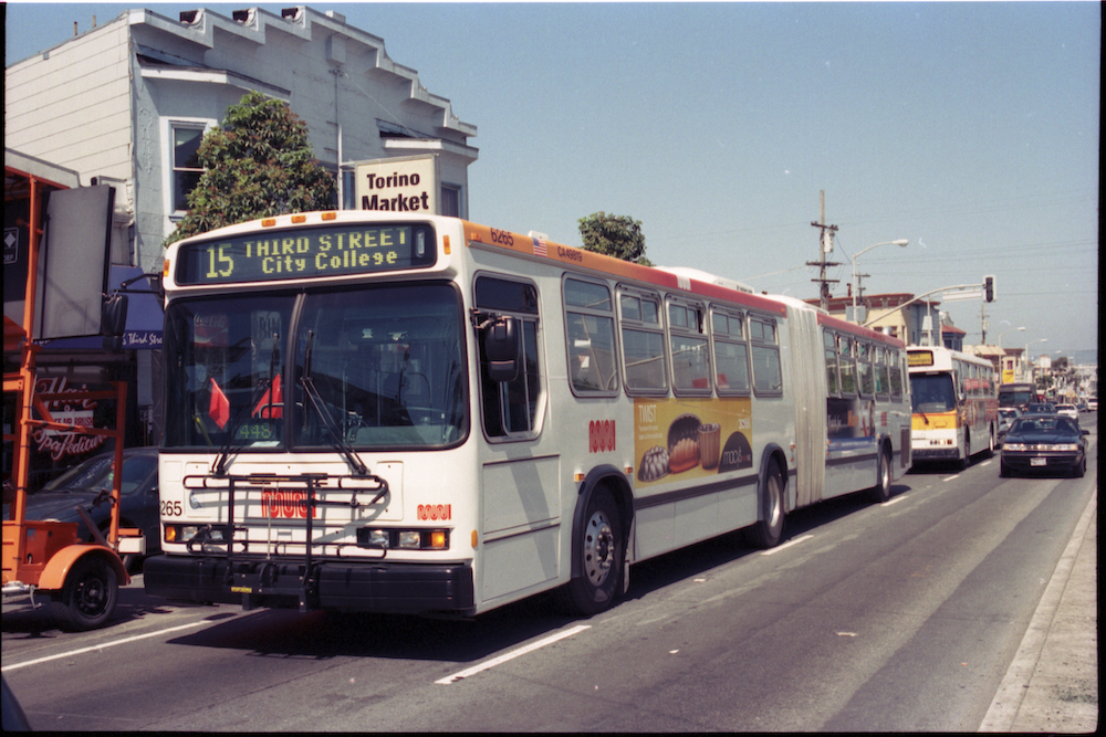 An articulated bus and coach seen traveling on a busy street