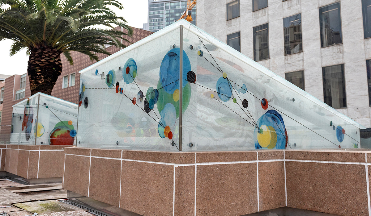 Glass artwork on top of the Union Square/Market Station depicts a topographic map of San Francisco with painted circles that reference Bay Area commute pattern densities. 