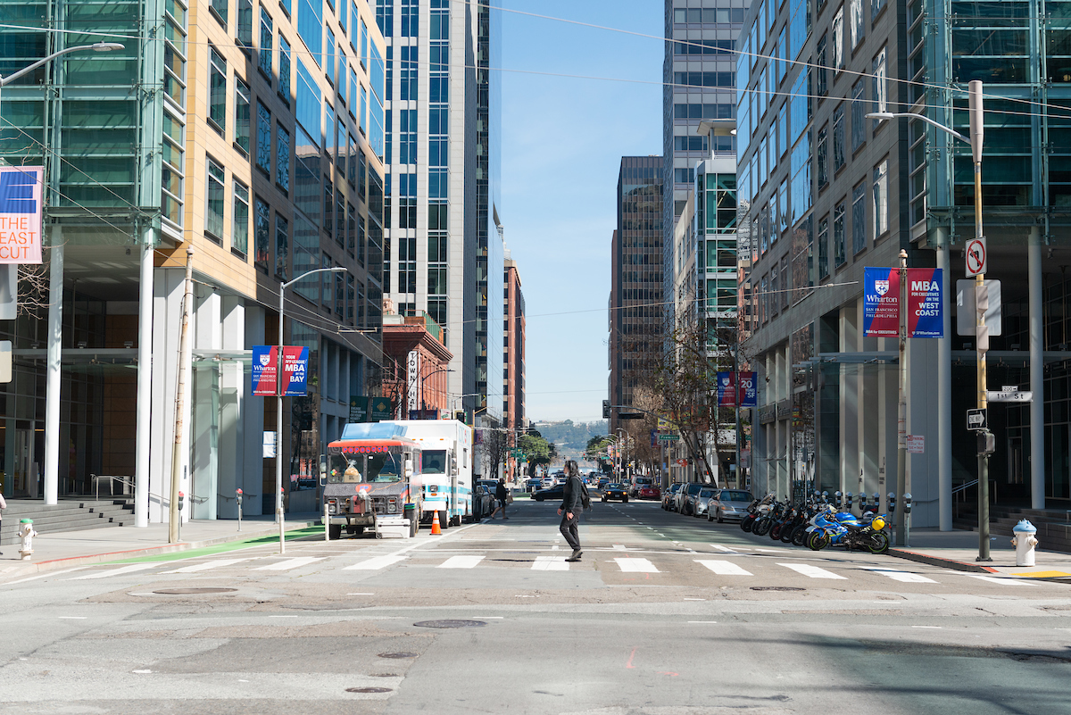 Person crossing Howard Street in the crosswalk with a food truck and office buildings in the background