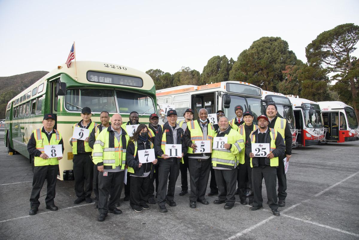 Operators standing in front of parked buses 