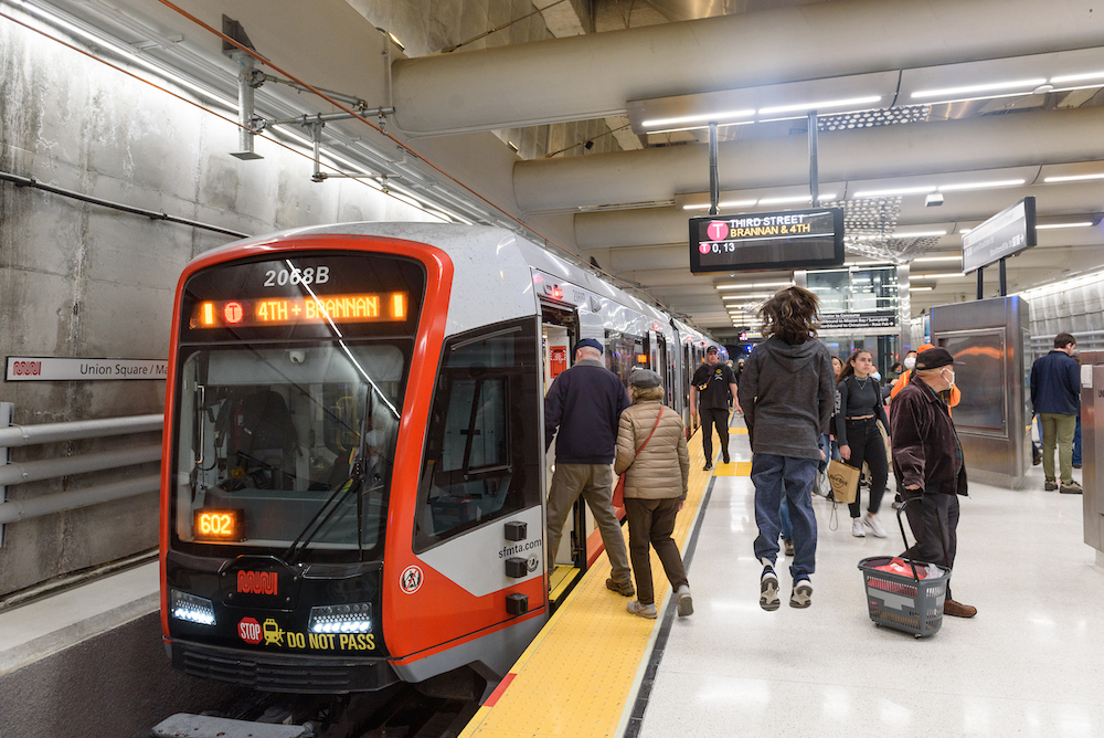 Passengers boarding onto a train in a station on a busy platform