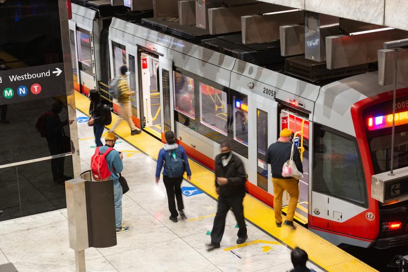 Photo of various Muni riders boarding a Muni Metro train in the subway