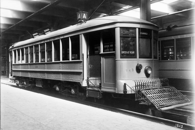 front and side view of old-style streetcar. Route reads "A". Headsign reads "Ferries". Sign reads "Enter at rear". Car is branded "Municipal Railway".