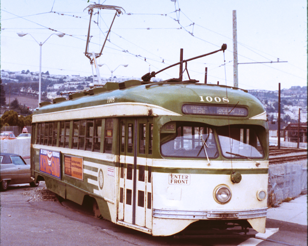 Streetcar 1008 painted green and cream colors with pantograph installed in place of trolley pole.