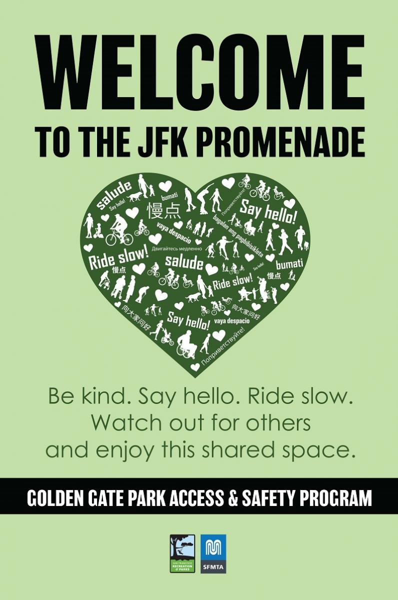 A pale green sign with a dark green heart in the middle. The sign reads Welcome to the JFK Promenade. Inside of the heart, the phrases “ride slow!” and “say hello!” are printed and translated into English, Russian, Tagalog, Spanish, and Chinese. Also inside the heart are silhouettes of park users, including people in wheelchairs, people pushing strollers, people walking, rollerskaters, kids, and cyclists. Underneath the heart, green text reads: “Be kind. Say hello. Ride slow. Watch out for others and enjoy this shared space.   At the bottom of the sign, there’s a black bar with white text that says: Golden Gate Park Access & Safety Program, and underneath are the SFMTA and Rec & Park logos. 